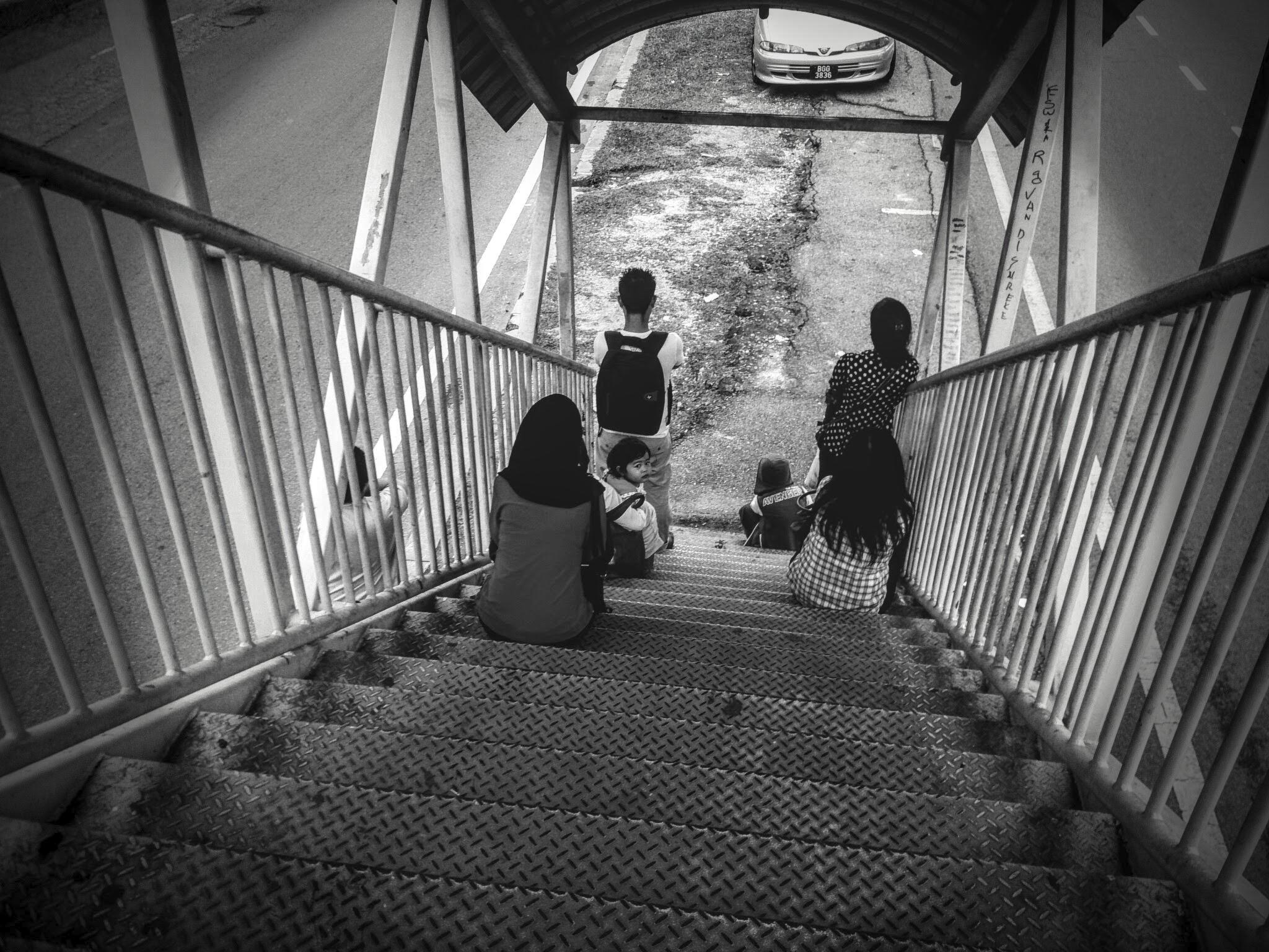 Malaysian children sitting on stairs waiting for bus, near SS13, Subang Jaya