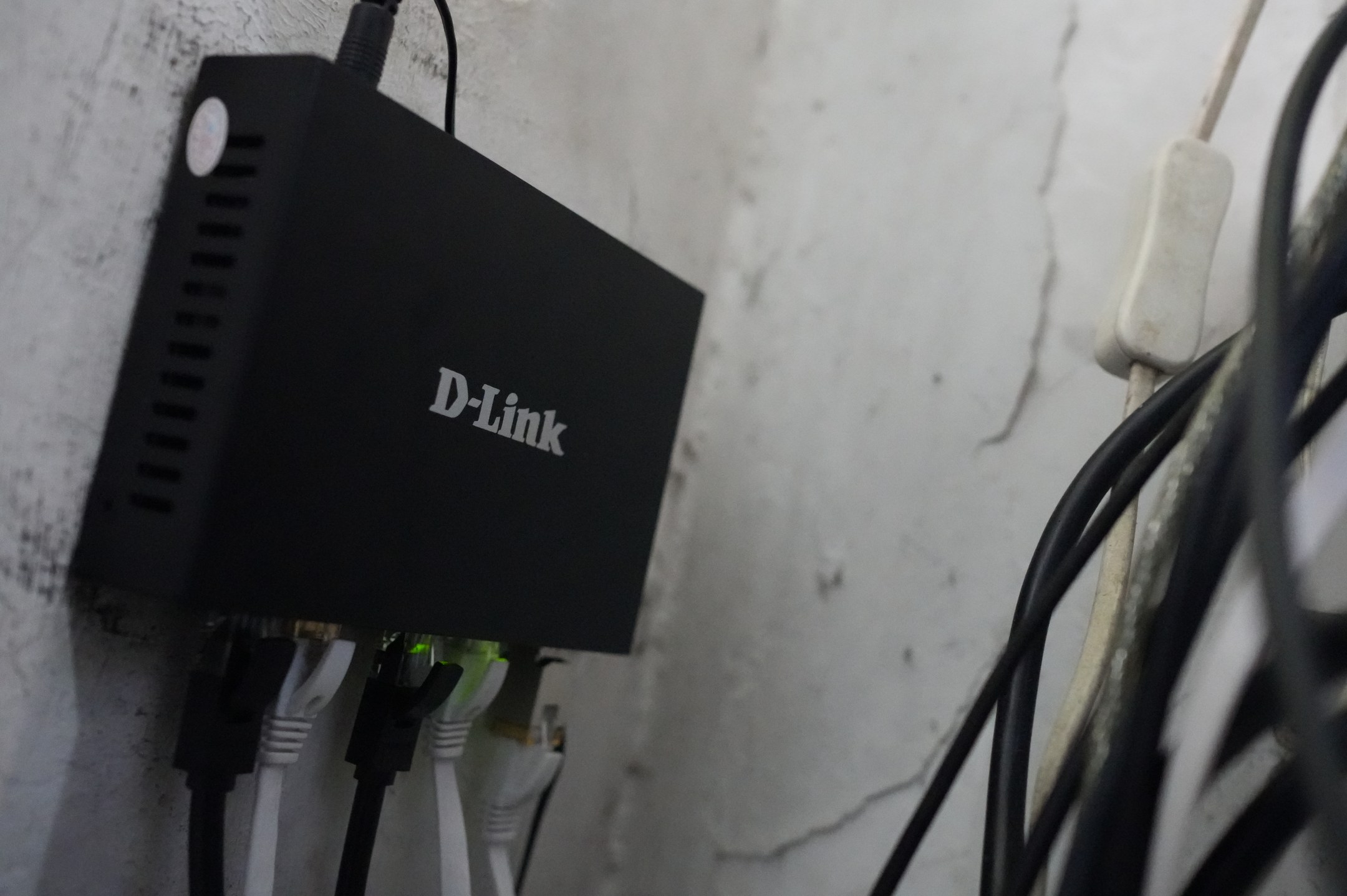 A wall-mounted D-Link DMS-F106TS 6-port managed switch with SFP+ module and ethernet cables is connected in a home network on July 08, 2026. The device was installed to manage network traffic and provide high-speed connectivity within the household's infrastructure. (Khairil Yusof)